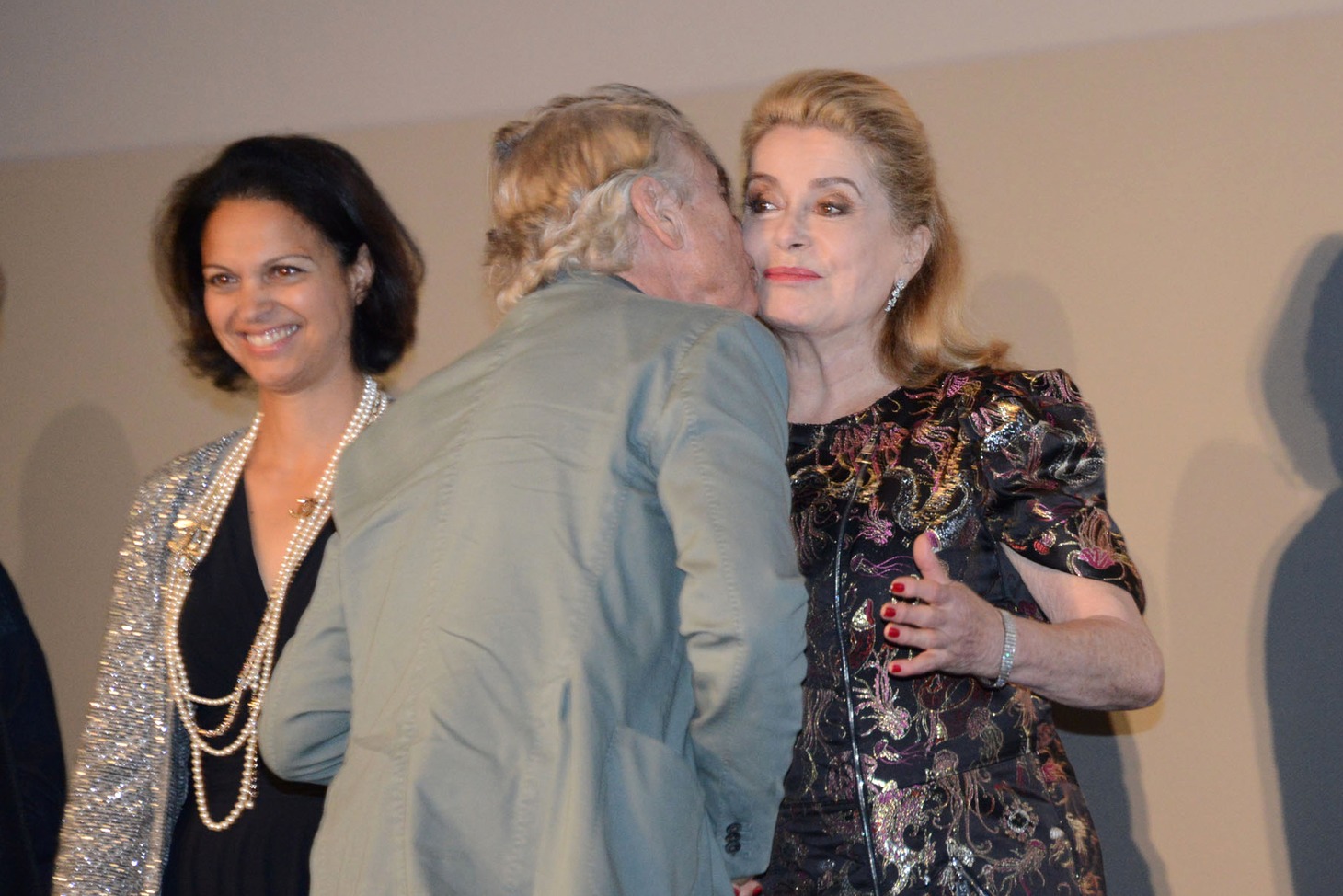 ポール・ヴァーホーヴェン（中央）からのキスを受けるカトリーヌ・ドヌーヴ（右）。