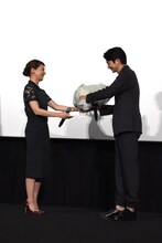 サプライズの気配に気付きながらも、尾野真千子（左）から花束を受け取る向井理（右）。