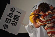 福田雄一（右）に着ぐるみの口を開けられて抵抗する山田孝之（左）。