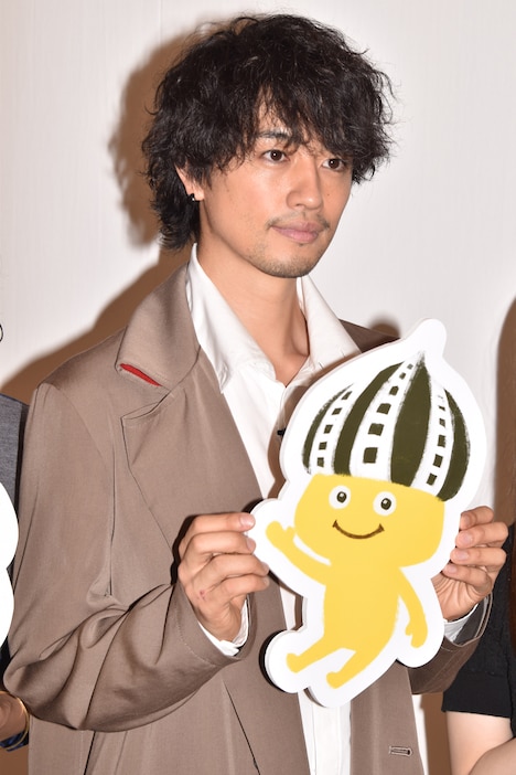 「映画の妖精 フィルとムー（仮題）」に登場するフィルのパネルを持つ斎藤工。