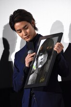 石田スイによるイラストを受け取った白石隼也。