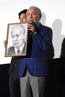 石田スイによるイラストを受け取った村井國夫。
