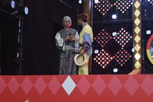 山崎大輝（左）のお面を落としてしまい、謝る榊原徹士（右）。