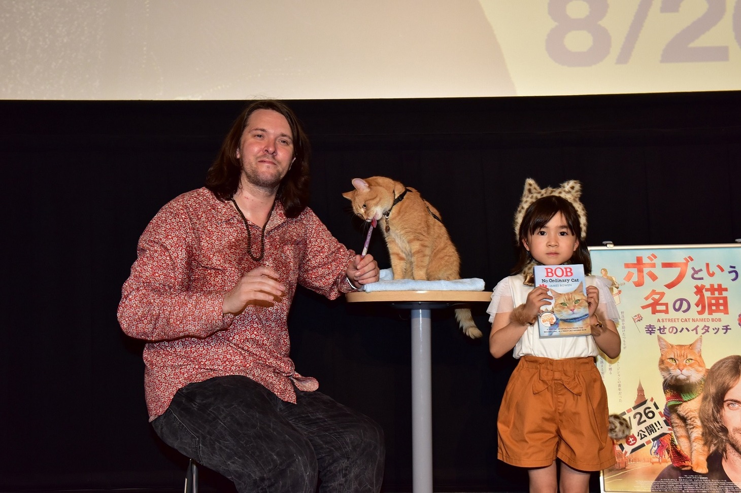 「ボブという名の猫 幸せのハイタッチ」ジャパンプレミアの様子。左からジェームズ・ボーエン、ボブ、新津ちせ。