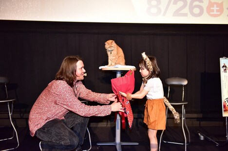 ジェームズ・ボーエン(左)に花束を渡す新津ちせ(右)。