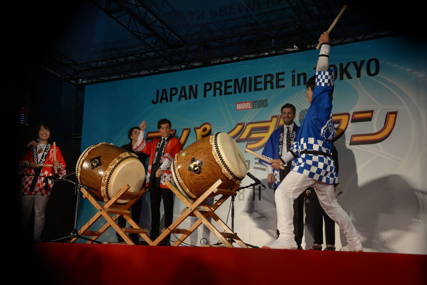 和太鼓の演奏を見ながら腕を上下に動かすトム・ホランド（中央奥）。