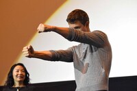 ドライバー風のポーズを取るアンセル・エルゴート。