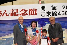 山田洋次（右）と450万人目の来館者（中央右）が記念撮影する様子。