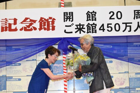 倍賞千恵子（左）が山田洋次（右）に花束を贈呈する様子。