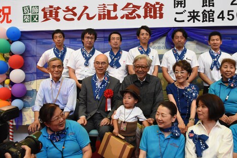 寅次郎の扮装をした子供（中央）を取り囲んだ記念撮影の様子。