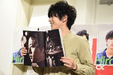 お気に入りのページを広げる飯島寛騎。