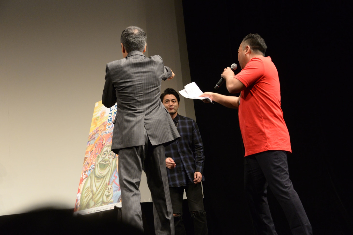 恐縮してステージの端に行き、司会者たちから呼び戻される山田孝之（奥）。