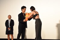 水原希子（右）から花束を受け取る妻夫木聡（中央）。