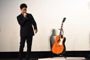 奥田民生のサイン入りギターを見つめる妻夫木聡。