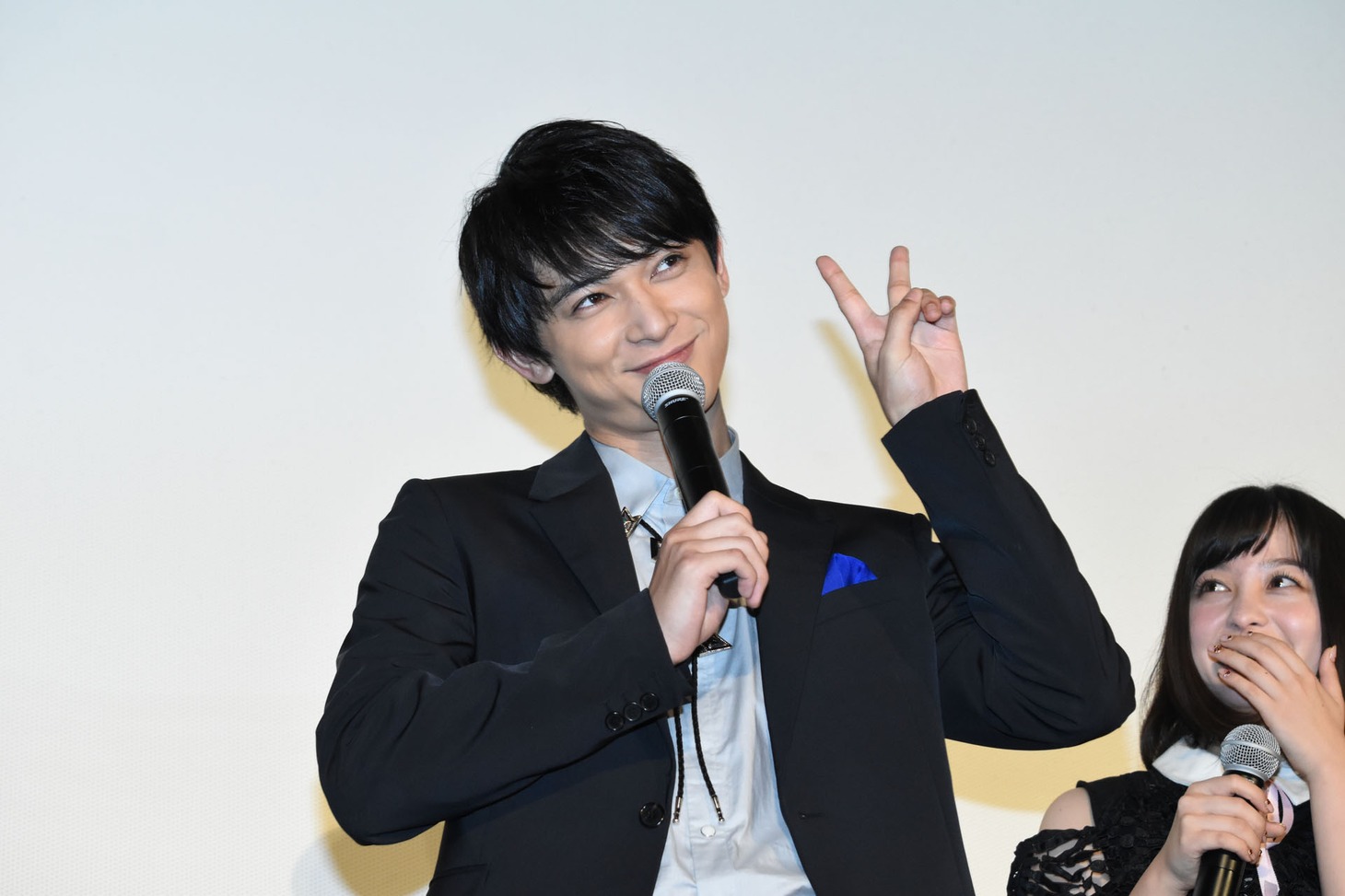 ファンが「ほほえみ王子」というプレートを持っていたことから福田雄一に「全然笑わないじゃん」と言われ、「笑いますよ！」とピースする吉沢亮。