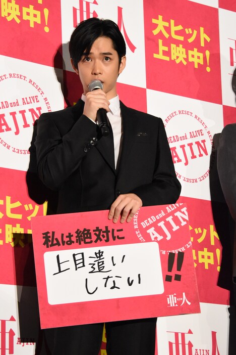 「私は絶対に上目遣いしない!!」と書かれたフリップを持ちながら、上目遣いをする千葉雄大。