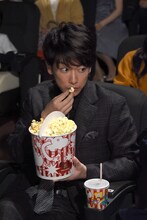 客席でポップコーンを食べる佐藤健。