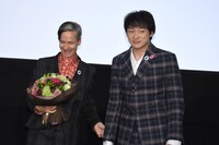 山本耕史（右）と、山本から受け取った花を見つめるジョン・キャメロン・ミッチェル（左）。