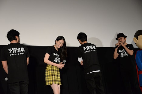 Tシャツのバックプリントを見せる登壇者たち。