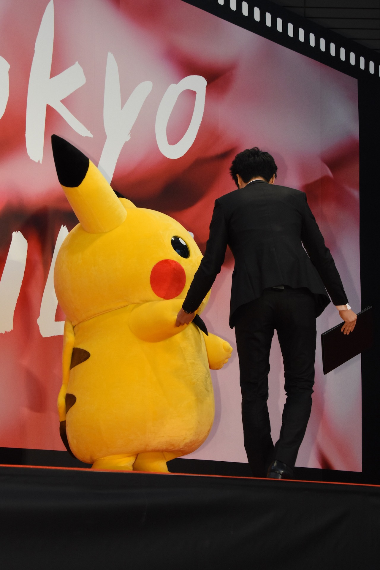 スタッフに手を引かれるピカチュウ。