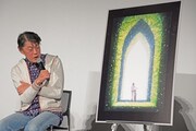 イメージボードを見ながら新作について話す原恵一。