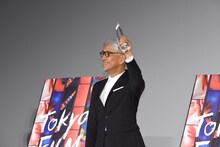 トロフィーを掲げる坂本龍一。