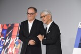 腕を組むスティーブン・ノムラ・シブル（左）と坂本龍一（右）。