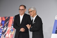 腕を組むスティーブン・ノムラ・シブル（左）と坂本龍一（右）。