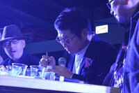 ファンが持参したペットボトルにサインをする松尾諭。