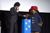 パディントン（右）の手をとる斎藤工（左）。