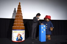 タワーの点灯ボタンを押す斎藤工（左）と、パディントン（右）。