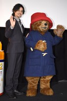 手を振る斎藤工（左）とパディントン（右）。