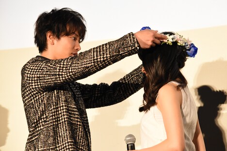 青いバラとダイヤモンドリリーで作られた花冠を土屋太鳳（右）に優しく被せる佐藤健（左）。