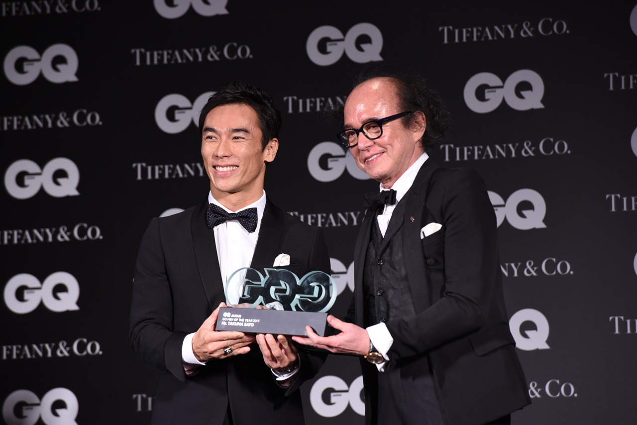 「GQ JAPAN」の鈴木正文編集長からトロフィーを受け取った佐藤琢磨（左）。