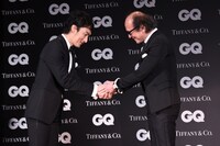 「GQ JAPAN」の鈴木正文編集長と握手を交わす草なぎ剛（左）。