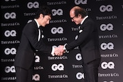 「GQ JAPAN」の鈴木正文編集長と握手を交わす草なぎ剛(左)。