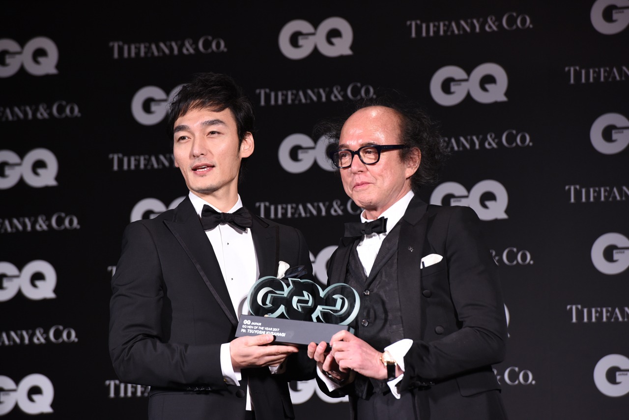 「GQ JAPAN」の鈴木正文編集長からトロフィーを受け取った草なぎ剛（左）。