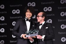 「GQ JAPAN」の鈴木正文編集長からトロフィーを受け取った斎藤工（左）。