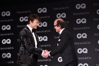 「GQ JAPAN」の鈴木正文編集長と握手を交わす香取慎吾（左）。