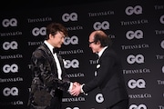 「GQ JAPAN」の鈴木正文編集長と握手を交わす香取慎吾(左)。