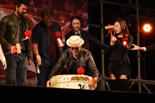 酒樽を持ち上げようとするマイケル・ルーカー（中央）。