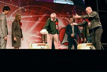 マイケル・ルーカー（前列右）の帽子を酒樽に入れようとするスタン・リー（前列中央）。