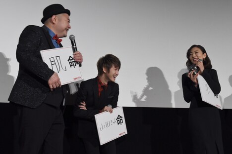 内山信二(左)からおにぎりを受け取った松雪泰子(右)。