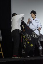 特攻服を着ようとする佐田正樹（左）。