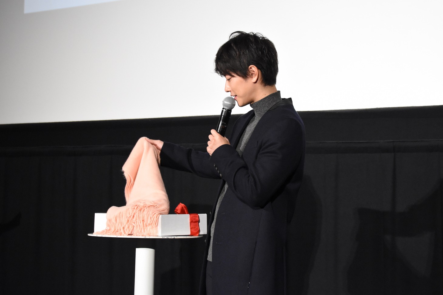 ファンに巻くためのマフラーを手に取る佐藤健。