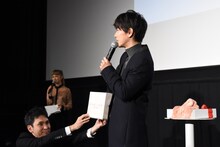 マフラーを巻くファンを決めるためのくじを引く佐藤健。