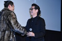 AKIRA（左）と握手を交わす井浦新（右）。