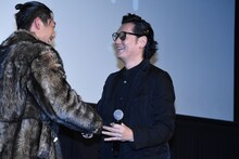 AKIRA（左）と握手を交わす井浦新（右）。