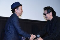 久保茂昭（左）と握手を交わす井浦新（右）。