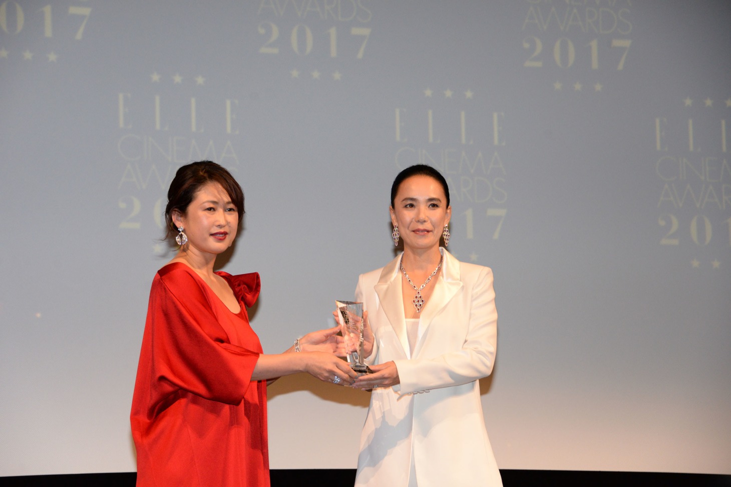 河瀬直美（右）がELLE編集長の坂井佳奈子（左）からトロフィーを受け取る様子。